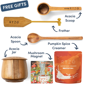 A product bundle graphic on a white background showing multiple RYZE branded items: a wooden scoop, frother, spoon, acacia jar, mushroom magnet, and an orange pouch of RYZE Superfood Creamer, with arrows and labels naming each item and a blue 'FREE GIFTS' banner.
