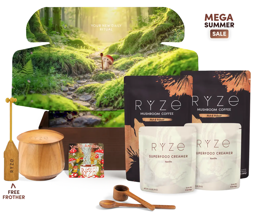 RYZE Mushroom Coffee Mega Summer Sale bundle featuring a large forest-themed gift box, two black and two white pouches of RYZE Mushroom Coffee and Superfood Creamer, a wooden chafing dish and spoon, a wooden spoon, and a wooden frother on a white background.