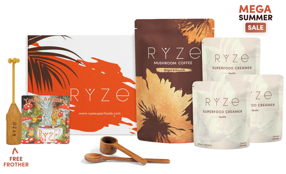 Ryze mushroom coffee and superfood creamer product lineup with a large orange and white box, a brown pouch labeled Ryze Mushroom Coffee, two white pouches of Ryze Superfood Creamer, two wooden spoons, a wooden measuring cup, and a small illustrated card, shown on a white background with a 'Mega Summer Sale' badge.
