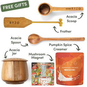 A product bundle graphic showing multiple RYZE branded items on a white background: a wooden scoop, a wooden frother, an acacia spoon, an acacia jar, a mushroom magnet, and a pouch of RYZE Superfood Creamer. Arrows and labels identify each item, with a green 'FREE GIFTS' banner at the top left.